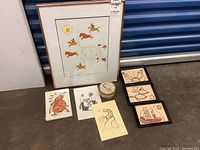 Full view of all seven pieces including framed prints, unframed prints on cards, and quill art circular container