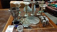Full view of the lot showing silver plate vases, silver plate salt and pepper shakers, glass salt cellar, silver plate stand, glass dish, and swan-shaped condiment containers arranged on a table.