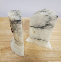 Two Italian marble bookends showing the natural black veining and arched base shape.