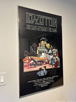 Framed Led Zeppelin colored poster titled 'The Song Remains The Same' showing detailed illustration and clear text