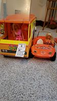 Barbie Country Camper and Dune Beach Buggy vehicles with 2 Barbie dolls placed inside and beside the vehicles.