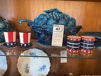 Full view showing grape-themed ceramic pieces alongside patriotic salt and pepper shakers, emphasizing the soup bowl and covered dish.