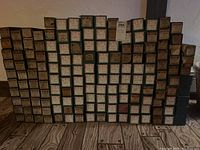 Frontal view of multiple stacked rows of vintage music roll boxes for player pianos, showing mostly QRS and U.S. branding.