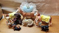 Whole lot of animal figurines including three Jersey cows, dogs, a cat and teddy bear, with visible broken ear on one cow.