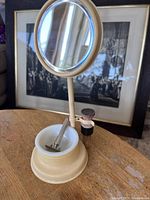 Shaving kit with mirror, razor placed inside cream dish in the beige base