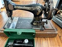 Side view of Singer sewing machine on wooden base with green accessory case