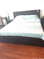 Front view of the king storage bed with bedding covering the mattress and headboard visible, showing the general appearance and overall size.