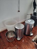 Full view of the four trash cans showing their size, material and pedal features