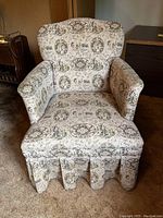 Full view of vintage upholstered armchair showing the patterned fabric and overall condition.