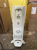 Front view of the Noma electric heater showing control panel with dial and power switches.