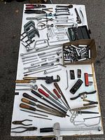 Full view of tools laid out on table showing various hand tools, files, clamps, pliers, planers, and socket sets.