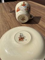 Photo of the cup and saucer showing the Bunnykins Royal Doulton logo on the base of the cup and saucer.