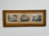 Full view of the framed etching prints set, showing three black and white prints and wooden frame.