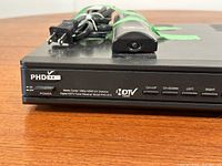 Front right close-up of PHD Digital HDTV tuner showing brand, model (PHD-BXV), media center 1080p HDMI A/V switcher, power button, and front control buttons.