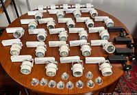 All 27 Rio track light fixtures laid out on a table with 14 halogen MR16 bulbs in front of them.