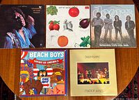 All five LP album covers together on wooden surface showing titles and artwork to identify each album.