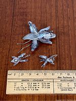 Front view of sterling silver brooch and earrings with ruler for size reference.