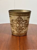 Full front view of the vintage Florentine waste basket showing its gold-tone embossed design and bucket shape.