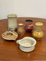 All six pottery and decor pieces arranged on wooden table