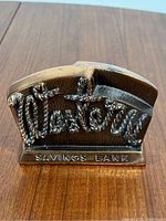 Front view of the vintage Western Savings Bank metal coin bank showing the embossed rope-like 'Western' lettering and 'SAVINGS BANK' at the base.