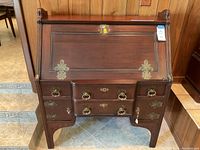 Full front view of the desk showing slant front, drawers, and brass embellishments