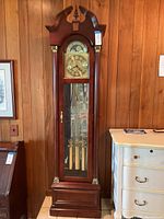 Full front view of the complete grandfather clock in its wooden case