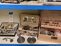 Overall view of multiple jewelry boxes and strands of pearls on shelf