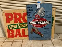 Photo showing Blue Streak ignition parts sign with details and two Pro Ball signs partially visible.