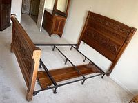 View of complete bed frame assembled showing headboard, footboard, side rails, and metal frame.