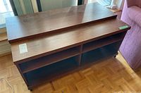 Media stand front view showing the top surface and the four open compartments beneath.