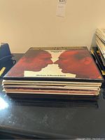 Stack of vinyl records showing album spines and covers, indicating a collection of comedy and audio-themed records.