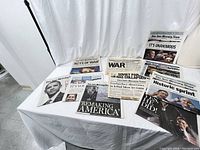 Collection of San Jose Mercury News newspapers laid out on table showing front page headlines covering various historic events