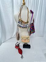 Front view of six tribal and vintage handbags with various colors and styles displayed on a dress form.