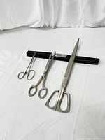 Three vintage scissors of various sizes laid out flat showing full length and details.