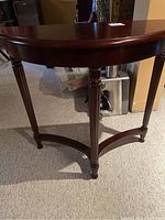 Full view of the half circle Bombay hall table showing the tabletop surface and legs