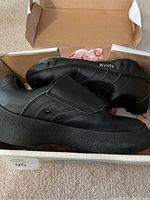 Pair of black Asham men's curling shoes in size 9 shown in the original box, highlighting the design and condition.