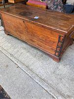 Full side angle view of rectangular cedar wood chest showing iron corner detail and side handle