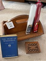 Wooden holder with candles, book, and carved wooden box displayed together