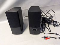 Pair of black Bose Companion 2 multimedia speakers with volume and headphone jack visible on the right speaker.
