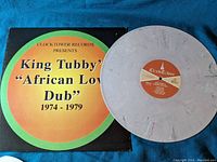 Vinyl record and sleeve showing 'King Tubby African Love Dub 1974-1979' title and label with mauve colored vinyl disc.