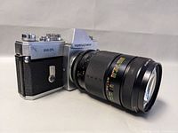 Front-left perspective of camera body mounted with Sigma 200mm f/3.5 lens showing '500 DTL' label and lens barrel markings.