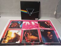 Front of Pink Floyd vinyl album sleeve and colorful poster showing band members with letter overlay