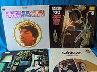 Four vinyl LP records with covers shown front facing. Top left is a white cover with photo of Manitas de Plata titled 'Flamenco Flamenco'. Top right is black cover titled 'Narciso Yepes Spanish Guitar Music' with guitar artwork. Bottom left is a photo cover showing Andres Segovia sitting in living room with guitar titled 'My Favorite Spanish Encores'. Bottom right is a white cover with photo of flamenco dancers and Sabicas titled 'Flamenco Fiesta'.