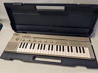 Yamaha PortaSound PC-100 keyboard open in hard plastic carrying case