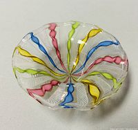 Top view of the Murano glass dish showing multicolor twisted ribbons and white filigree patterns inside clear blown glass.