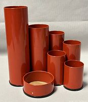 Front view showing all seven orange metal holders arranged in ascending height order