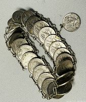 Close-up of the bracelet showing linked 10 peso coins from 1980 with the hook clasp made from a coin.