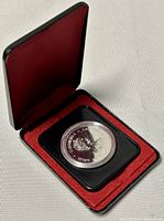 Silver Canadian Royal Jubilee coin in protective plastic casing inside red velvet-lined black display box.