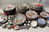 Overview of entire dishware set showing stacks of plates, cups, serving pieces and tureen