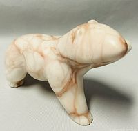 Side view of the rose alabaster bear sculpture showing natural veining and proportions.